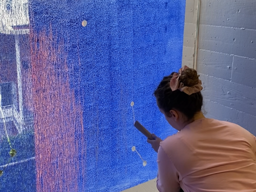 alumna pintant constel·lacions a la finestra