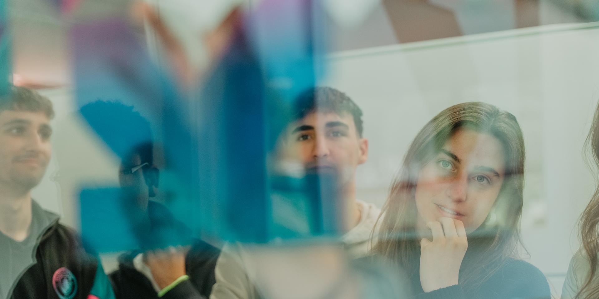 Estudiants miren un treball a una pissarra