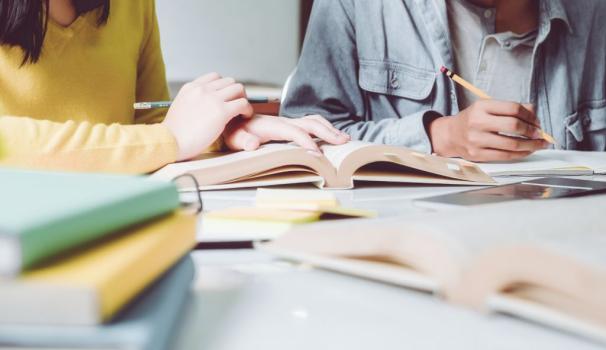 Estudiants complementant els apunts amb un llibre de text