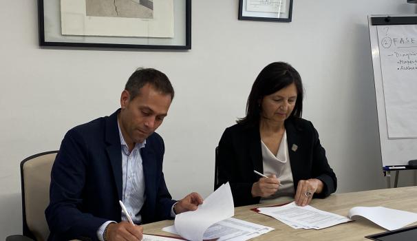 El Dr. Marc Franco i la Dra. Claudia Peirano signant el conveni