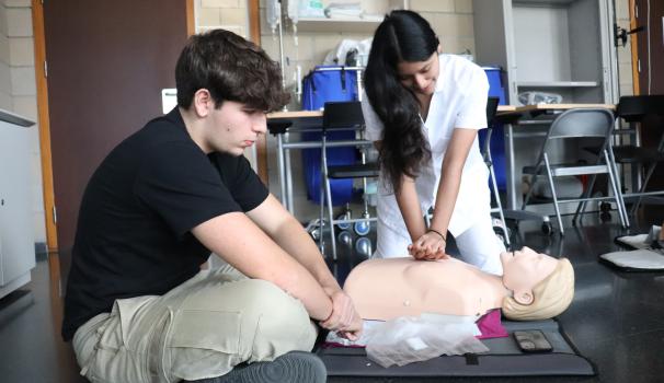 Dos estudiant d'infermeria practicant fer CPR a un maniquí