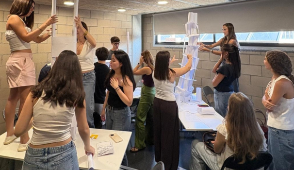 L'alumnat a l'aula, pujats a les aules, construint unes torres de paper