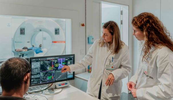 Alumnat del grau en Medicina i professora de l'hospital revisen uns resultats del TAC a l'ordinador
