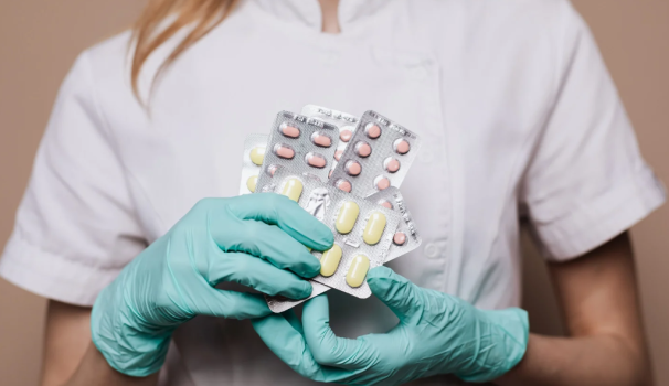 Unes mans i mig cos de dona amb guants quirúrgics aguanten medicaments